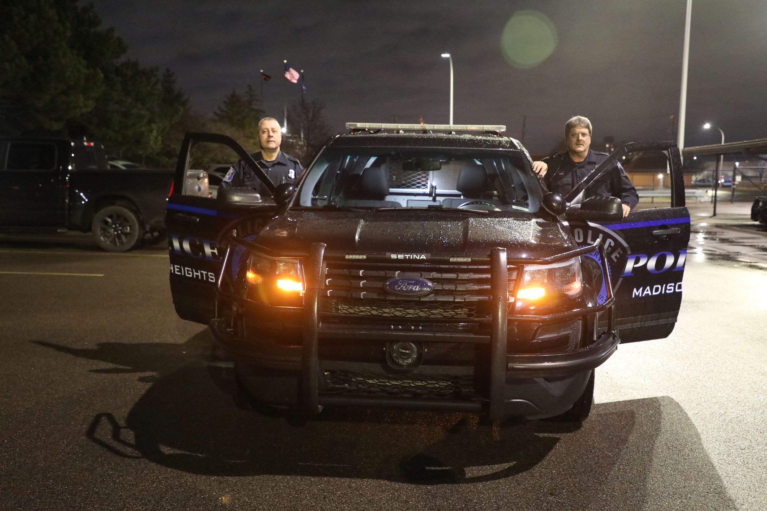 Police Car with two men standing at the doors