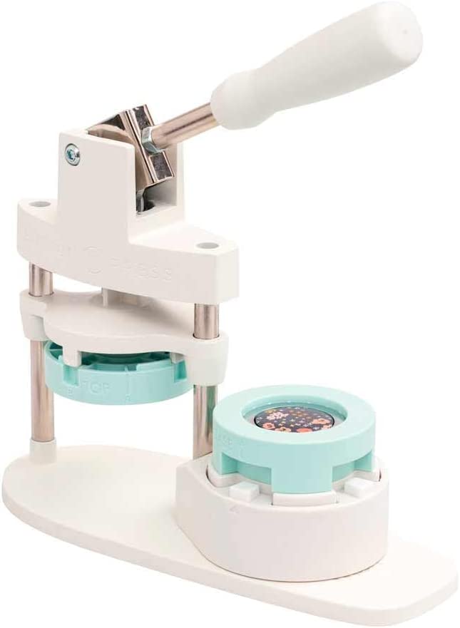 We R Memory Keepers Button Press: white button press with blue die cut insert.